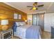 Well-decorated bedroom featuring wood accent wall, ceiling fan, and access to the bathroom at 4560 Greenbriar Dr. # 306B, Little River, SC 29566