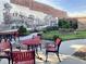 A charming outdoor seating area with red tables and chairs in a garden setting at 476 Honeyhill Loop, Conway, SC 29526