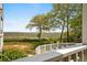 Relaxing view of the marsh from the backyard, complete with a white fence and lush greenery at 4999 Highway 17 Business # 302, Murrells Inlet, SC 29576