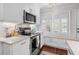 Well-lit kitchen with stainless steel appliances, white cabinets and shutters on the window at 4999 Highway 17 Business # 302, Murrells Inlet, SC 29576