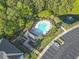 Aerial view of a community pool, clubhouse, parking lot, pond with fountain, and surrounding greenery at 5750 Oyster Catcher Dr. # 714, North Myrtle Beach, SC 29582