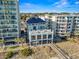 Beachfront building featuring multiple floors of amenities with ocean views, palm trees, and a boardwalk at 5750 Oyster Catcher Dr. # 714, North Myrtle Beach, SC 29582