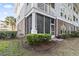 Exterior of a condo with brick foundation, screened porch, and landscaped surroundings at 5750 Oyster Catcher Dr. # 714, North Myrtle Beach, SC 29582
