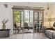 Living room view to a screened porch with seating overlooking the lawn and trees at 5750 Oyster Catcher Dr. # 714, North Myrtle Beach, SC 29582