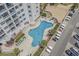 Aerial view of a resort pool with lounge chairs and a parking lot filled with golf carts at 5905 S Kings Hwy. # 1612, Myrtle Beach, SC 29575