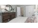 Bedroom with a dark wood dresser with round mirror and white trim including doors and closet at 615 Forage Dr, Conway, SC 29526