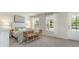 Light and airy bedroom with neutral walls, two large windows, bed, side table, and bench seating at 615 Forage Dr, Conway, SC 29526