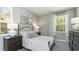 Bright bedroom features two large windows, neutral walls, carpet, bed, dresser, and lamps at 615 Forage Dr, Conway, SC 29526