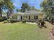Spacious backyard featuring a patio with outdoor seating, surrounded by lush greenery and mature trees at 64 Reef Run Rd., Pawleys Island, SC 29585