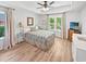 Light filled bedroom is complete with wood-look floors and multiple windows at 64 Reef Run Rd., Pawleys Island, SC 29585