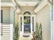 Inviting front door with sidelights and decorative accents, framed by manicured shrubs at 64 Reef Run Rd., Pawleys Island, SC 29585