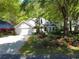 Charming home featuring an attached garage, complemented by lush landscaping and mature trees at 64 Reef Run Rd., Pawleys Island, SC 29585