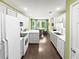 Bright eat-in kitchen features white cabinetry, stainless steel appliances, and wood floors at 64 Reef Run Rd., Pawleys Island, SC 29585