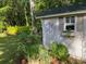 Charming garden shed with shutters, window box, and decorative artwork at 64 Reef Run Rd., Pawleys Island, SC 29585