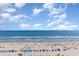 Expansive ocean view with a sandy beach, clear skies, and beachgoers at 7100 N Ocean Blvd. N # 912, Myrtle Beach, SC 29572
