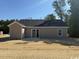 View of home's backyard featuring a sliding glass door and adjacent concrete patio at 8062 Mill Pond Rd., Galivants Ferry, SC 29544