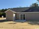 View of home's backyard featuring a sliding glass door and adjacent concrete patio at 8062 Mill Pond Rd., Galivants Ferry, SC 29544