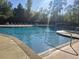 Community pool with clear water, lounge chairs, and surrounding trees for a relaxing atmosphere at 897 Wild Leaf Loop, Conway, SC 29526