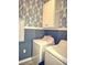 Well-lit laundry room with a blue accent wall and washer and dryer at 897 Wild Leaf Loop, Conway, SC 29526