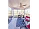 Inviting screened porch featuring comfortable wicker seating, stylish rug, and a peaceful backyard view at 897 Wild Leaf Loop, Conway, SC 29526