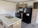 Kitchen featuring wood-look cabinets, a black refrigerator, and a kitchen island at 928 Baron Ln., North Myrtle Beach, SC 29582
