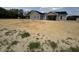 Rear exterior of a home with gray siding, black roof, sliding glass doors, and a large yard at Tbd 61 Persimmon Rd., Aynor, SC 29511