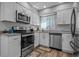 Galley kitchen with white cabinets, granite counters, stainless steel appliances, and wood-look flooring at 10301 N Kings Hwy. # 8-1, Myrtle Beach, SC 29572