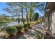 Backyard patio with a view of a lake, mature trees and seating arrangements at 111 Cedar Ridge Ln., Conway, SC 29526