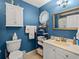 Stylish bathroom with blue walls, tiled floors, and a white vanity with gold hardware at 111 Cedar Ridge Ln., Conway, SC 29526