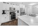 Modern kitchen features white cabinets, stainless steel appliances, marble countertops, and dark wood flooring at 115 Foxford Dr., Conway, SC 29526