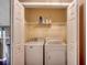 Functional laundry area with washer, dryer, and storage shelf inside a closet at 1154 Lampwick Ln., Murrells Inlet, SC 29576