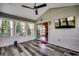 Bright sunroom with many windows, wood-look floors, neutral walls, and mounted TV at 1154 Lampwick Ln., Murrells Inlet, SC 29576