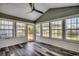 Bright sunroom featuring many windows, wood-look floors, neutral walls, and a ceiling fan at 1154 Lampwick Ln., Murrells Inlet, SC 29576