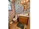 Functional bathroom with a floral wallpaper, toilet, sink, and wood-look flooring at 116 Green Lake Dr., Myrtle Beach, SC 29572