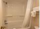 Bathroom featuring a shower and tub combo with white shower curtain and tiled walls at 1200 N Ocean Blvd. N # 905, Myrtle Beach, SC 29577