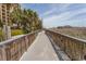 View down a wooden boardwalk lined with dune vegetation with buildings in the background at 1200 N Ocean Blvd. N # 905, Myrtle Beach, SC 29577