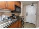Close-up of a kitchenette with stainless steel sink, microwave, and granite countertops at 1200 N Ocean Blvd. N # 905, Myrtle Beach, SC 29577