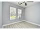 Bright bedroom featuring a ceiling fan, two windows, and wood-look flooring at 121 Olde Towne Way # 2, Myrtle Beach, SC 29588