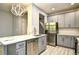 Open kitchen boasts gray cabinets, stainless steel appliances, and a stylish light fixture at 121 Olde Towne Way # 2, Myrtle Beach, SC 29588