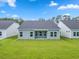 Backyard view featuring a large grassy lawn and the rear of the house with a covered patio at 1226 Nw Calabash Station Blvd., Calabash, NC 28467
