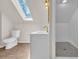 Bathroom features a modern shower and a toilet under a skylight at 129 Old Cedar Loop, Pawleys Island, SC 29585
