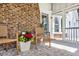 Relaxing screened-in porch featuring brick fireplace, seating, rug, and welcome mat at 129 Old Cedar Loop, Pawleys Island, SC 29585