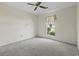 This carpeted bedroom has a ceiling fan and a window with a sheer curtain at 1406 Snowy Egret Dr., Murrells Inlet, SC 29576