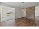 Bright dining area with hardwood floors, brick wall, and view to sunroom at 1406 Snowy Egret Dr., Murrells Inlet, SC 29576