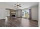 Living room features modern wood floors, a brick fireplace, and a large window with natural light at 1406 Snowy Egret Dr., Murrells Inlet, SC 29576