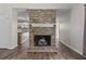 Open living room with a striking brick fireplace and modern wood floors at 1406 Snowy Egret Dr., Murrells Inlet, SC 29576