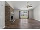 Bright living room showcasing a brick fireplace, wood flooring, and a view to the yard at 1406 Snowy Egret Dr., Murrells Inlet, SC 29576