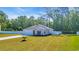 Single-story home featuring a green lawn, concrete driveway, attached garage, and a backdrop of lush trees at 146 Brittmore Park Pl., Myrtle Beach, SC 29588