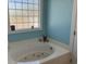 Spacious bathroom with a large soaking tub, decorative glass-block window, and modern fixtures at 1516 Edge Dr. # 101, North Myrtle Beach, SC 29582