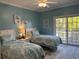 Comfortable bedroom featuring two beds, ceiling fan, sliding glass door and tasteful decor at 1516 Edge Dr. # 101, North Myrtle Beach, SC 29582